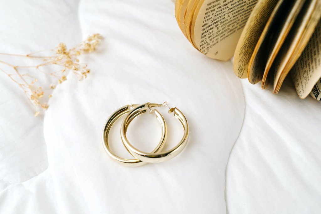 Golden modern bijouterie earrings on white background.
